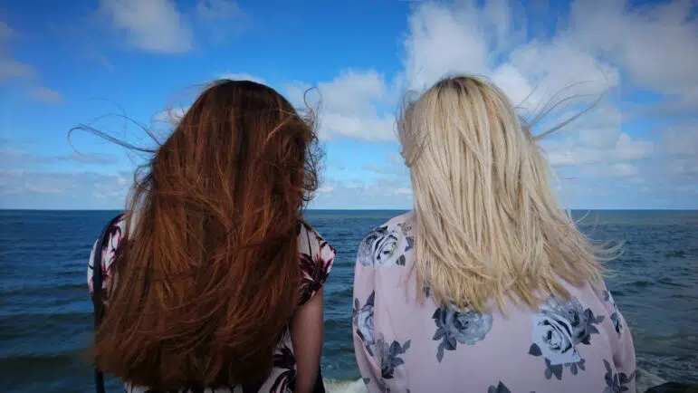 Two women sitting together confiding in one another